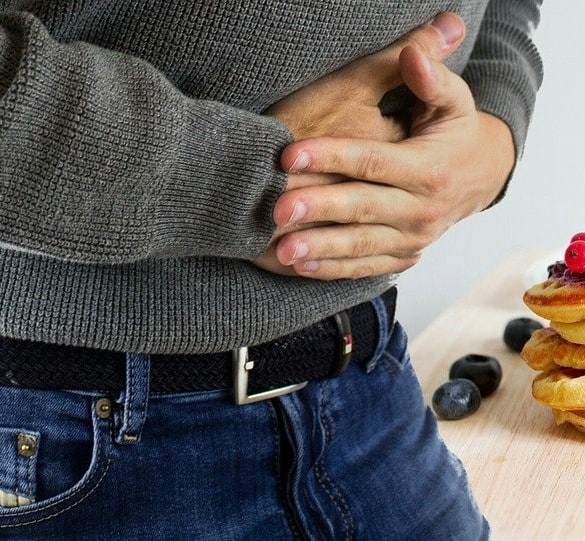 Photo d'une personne se tenant le ventre pour soulager ses douleurs digestives
