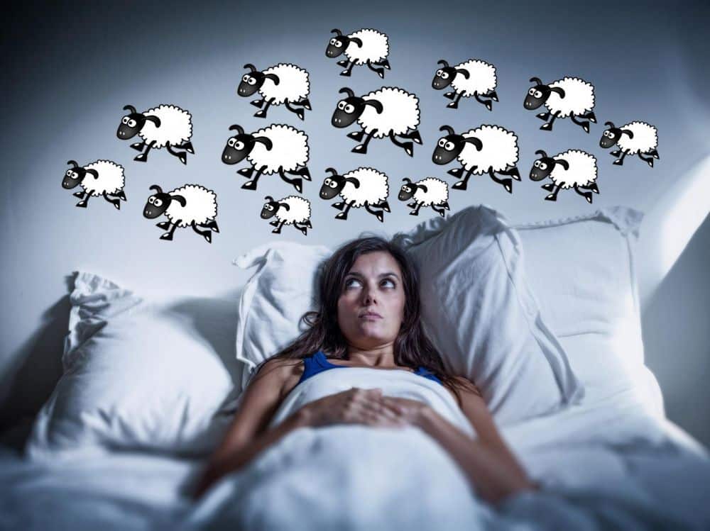 Photo d'une personne qui n'arrive pas à dormir et qui compte les moutons.