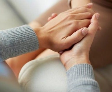 Photo d'une personne tenant les main d'une autre personne pour l'accompagner dans ses troubles de santé