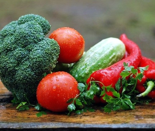 Photo de légumes frais, on retrouve des tomates, brocolis, un concombre et des piments.